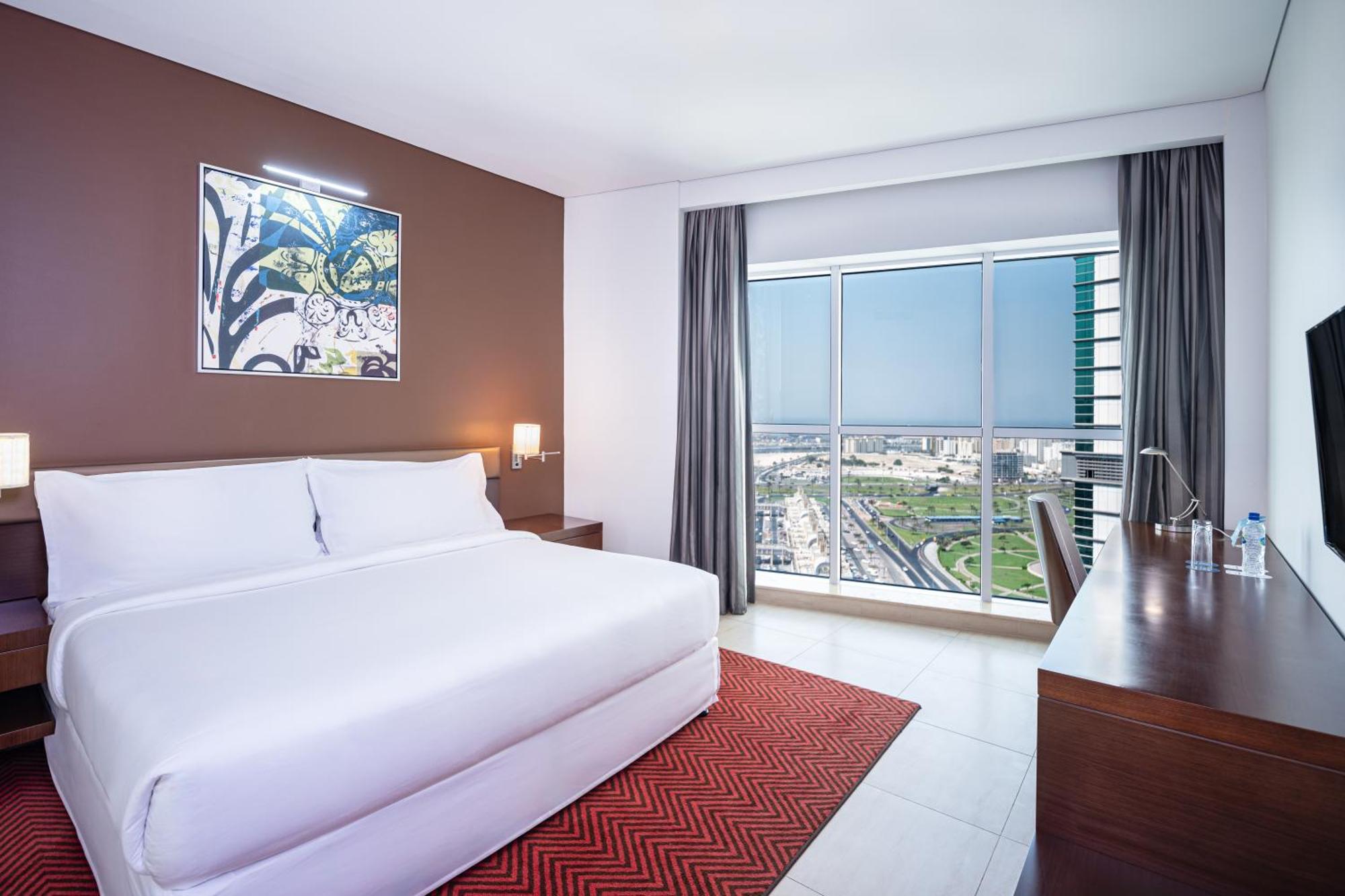 Executive Zimmer mit Kingsize-Bett und Blick auf die Skyline