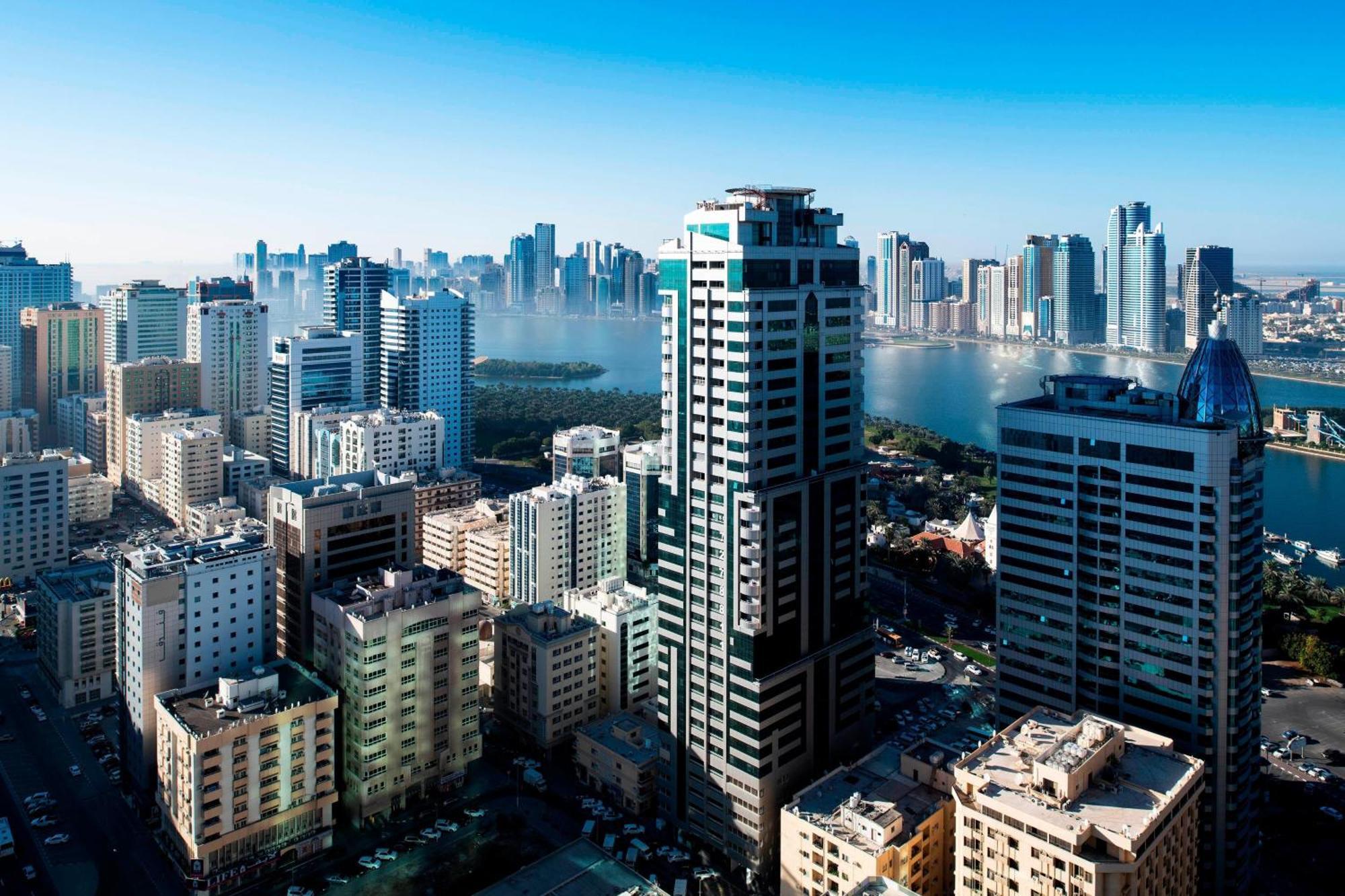 Größere Suite Sharjah mit 1 Schlafzimmer mit Kingsize-Bett und Blick auf die Skyline
